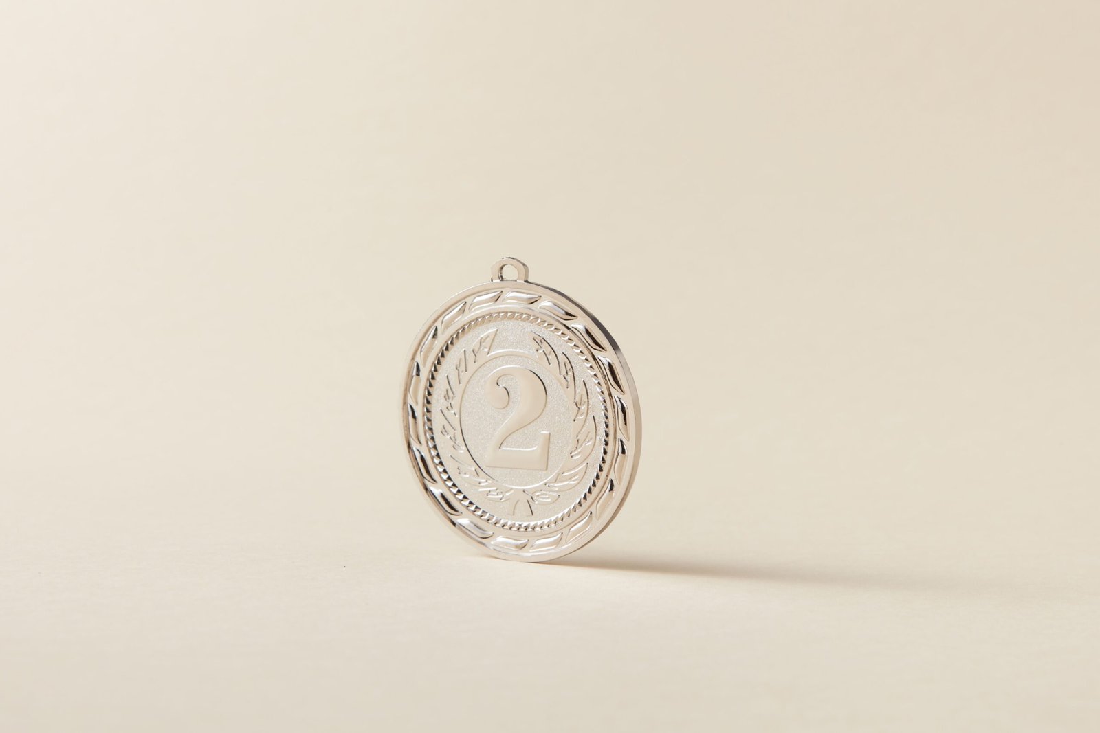 A shiny silver medal featuring the number two on a neutral, light background.